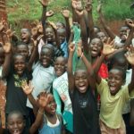 children raising hands and jumping for joy