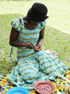 young woman making bead necklace